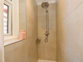 A shower with tiles and a window at The Pines in Bournemouth
