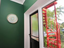 A corner with a clock and a window showing a red spiral staircase at The Pines Bournemouth