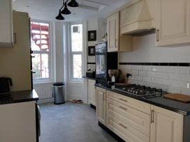 A kitchen with cabinets, a gas stove, and a refrigerator at The Pines in Bournemouth