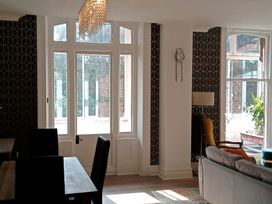A living room with windows and a sofa at The Pines in Bournemouth
