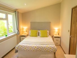A bedroom with a bed and bedside tables at Ash Lodge Stowmarket