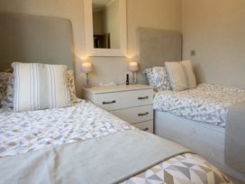 A bedroom with twin beds and a nightstand at Ash Lodge in Stowmarket