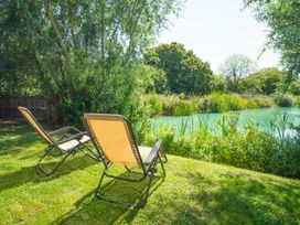 A garden with sun loungers and water at Ash Lodge in Stowmarket