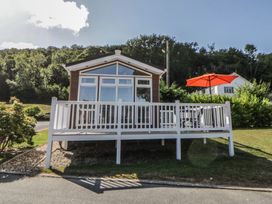 A house with a deck and an umbrella at 73 Cildraeth in New Quay