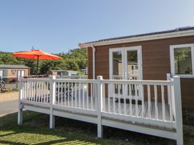 An outdoor area with a deck and umbrella at 73 Cildraeth New Quay