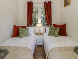 A bedroom with two beds and a lamp on a nightstand at 73 Cildraeth in New Quay