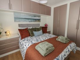 A bedroom with a bed and wardrobe at 73 Cildraeth New Quay