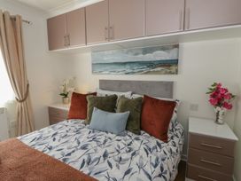 A bedroom with a bed and bedside table at 73 Cildraeth in New Quay