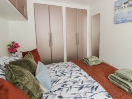 A bedroom with a bed and wardrobe at 73 Cildraeth New Quay