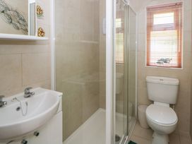 A bathroom with a shower, sink, and toilet at 73 Cildraeth in New Quay