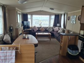 A living room with a sofa and television at Stoup cross caravan park in Whitby