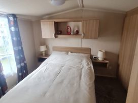 A bedroom with a bed and bedside lamps at Stoup cross caravan park in Whitby