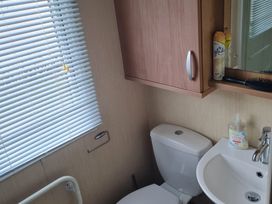 A bathroom with a toilet and sink at Stoup cross caravan park in Whitby