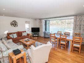 A living room with a sofa and dining area at 33 Dart Marina in Dartmouth