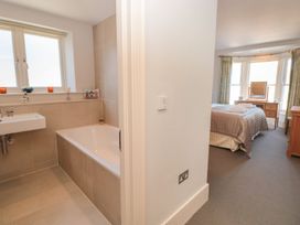 A bathroom with a bathtub and sink leading to a bedroom at 33 Dart Marina Dartmouth