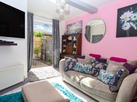 A living room with a sofa and a TV at Angels Place in Yelverton