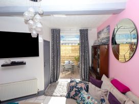 A living room with a television and dining area at Angels Place in Yelverton