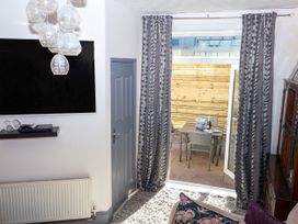 A living room with a television and a sliding door at Angels Place Yelverton