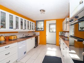 A kitchen with white cupboards and appliances at Angels Place in Yelverton