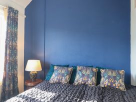 A bedroom with a bed and lamp at Angels Place in Yelverton