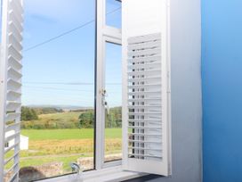 A window with shutters and a view of the landscape at Angels Place in Yelverton