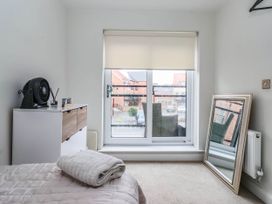 A bedroom with a fan, drawer unit, mirror, bed and blanket at Blanket Row in Hull