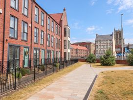 A row of townhouses with a pathway and trees at Blanket Row in Hull
