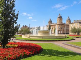 A fountain with flower beds and trees at Blanket Row in Hull