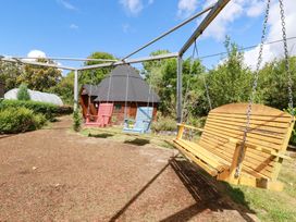 A garden with a wooden swing and garden shed at The Hyde, Tazamble cottage Launceston