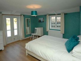 A bedroom with a bed and chair at Old Lyn Cottage in 