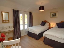 A bedroom with two beds and a sink at Old Lyn Cottage