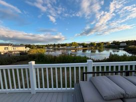 A view of a lake and houses from a deck at Haggerston Castle - Lakeside Retreat, Berwick-upon-Tweed