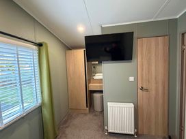 A bedroom with a television and wardrobe at Haggerston Castle - Lakeside Retreat, Berwick-upon-Tweed