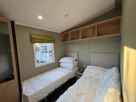 A bedroom with two beds and a window at Haggerston Castle - Lakeside Retreat Berwick-upon-Tweed