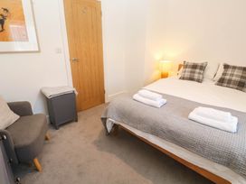 A bedroom with a bed and armchair at Top Deck St. Ives