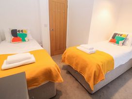 A bedroom with twin beds and wooden door at Top Deck in St. Ives