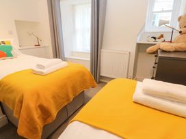 A bedroom with two beds and a teddy bear at Top Deck in St. Ives