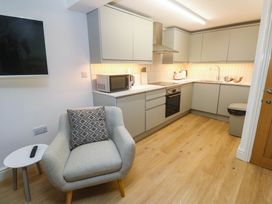 A kitchen with modern appliances and furniture at The Cabin in St Ives