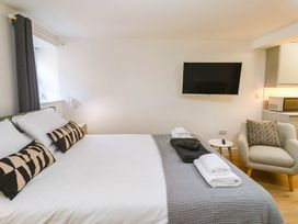 A bedroom with a bed and television at The Cabin in St Ives