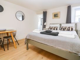 A bedroom with a bed and small dining area at The Cabin in St Ives
