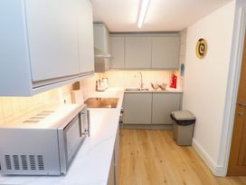A kitchen with microwave and sink at The Cabin in St Ives