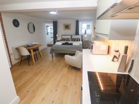 A studio with a bed, dining table, and kitchen area at The Cabin in St Ives