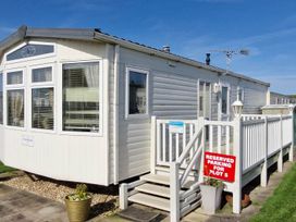 A mobile home with steps and a reserved parking sign at Beachcomber Cabin Dog Friendly Anderby Creek Lincolnshire
