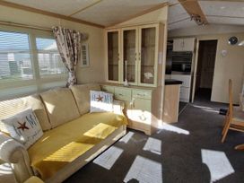 A living room with a sofa and a cabinet at Beachcomber Cabin Dog Friendly Anderby Creek Lincolnshire