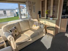 A living room with a sofa and coffee table at Beachcomber Cabin Dog Friendly Anderby Creek Lincolnshire