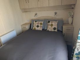 A bedroom with a bed and bedside table at Beachcomber Cabin Dog Friendly Anderby Creek Lincolnshire