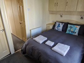 A bedroom with a bed and towels at Beachcomber Cabin Dog Friendly Anderby Creek Lincolnshire