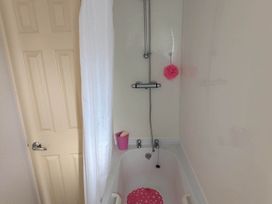 A bathtub with a shower and door at Beachcomber Cabin Dog Friendly Anderby Creek Lincolnshire
