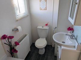 A bathroom with a toilet and sink at Beachcomber Cabin Dog Friendly Anderby Creek Lincolnshire