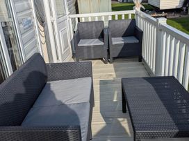 Outdoor seating area with a sofa and chairs at Beachcomber Cabin Dog Friendly Anderby Creek Lincolnshire